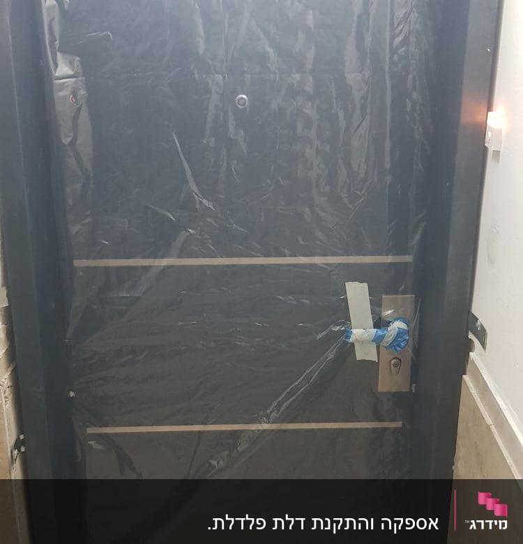 דלת מכוסה בניילון שחור עם ידית כסופה